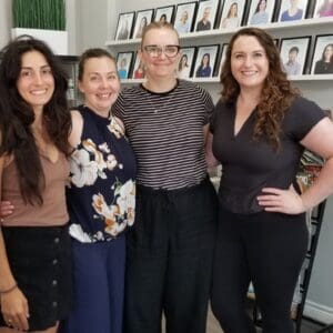 Four Hudson Integrative Healthcare team members smiling together inside the Stoney Creek clinic.