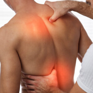 Manual therapist assessing and treating upper and lower back muscle tension