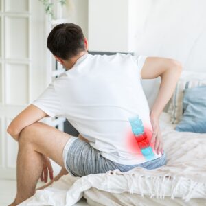 Man experiencing lower back pain with the lumbar spine highlighted