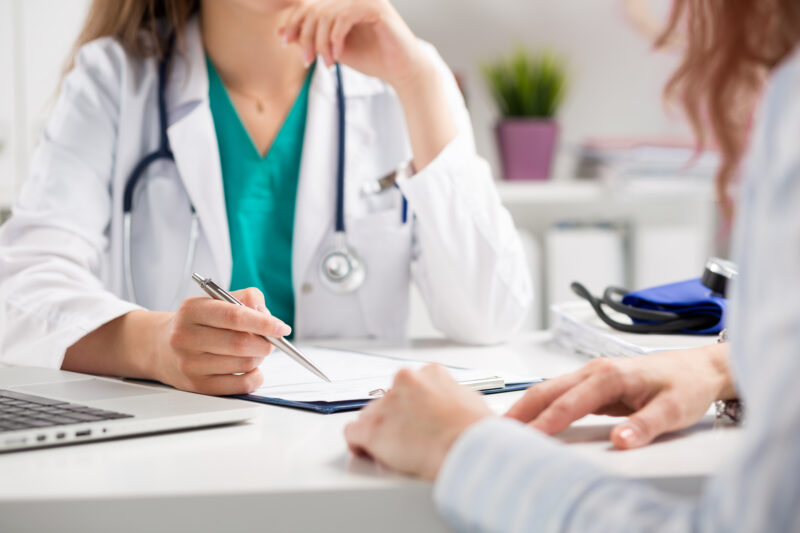 Healthcare practitioner discussing thyroid symptoms, bloodwork and treatment options with a patient.