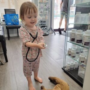 Toddler girl wearing a stethoscope at Hudson Integrative Healthcare, representing naturopathic pediatric appointments and family-centred care.