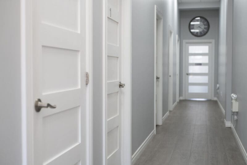 Hallway inside Hudson Integrative Healthcare with multiple private treatment room doors along a bright, modern clinic corridor.