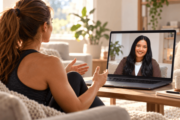Athlete participating in a virtual psychotherapy session with Registered Psychotherapist Sarah Prashad displayed on a laptop screen.